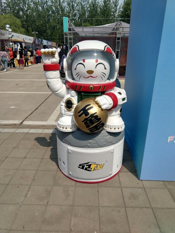 A lucky cat in an astronaut suit, arm raised, holding a ball. It's quite large.