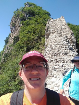 A selfie of me, with Linda in the background and a section of wall that looks like a vertical rockfall, basically. 