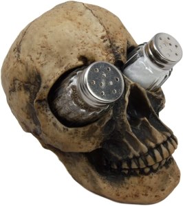 A fairly realistic fake human skull, with a salt and pepper shaker in the eye sockets.
