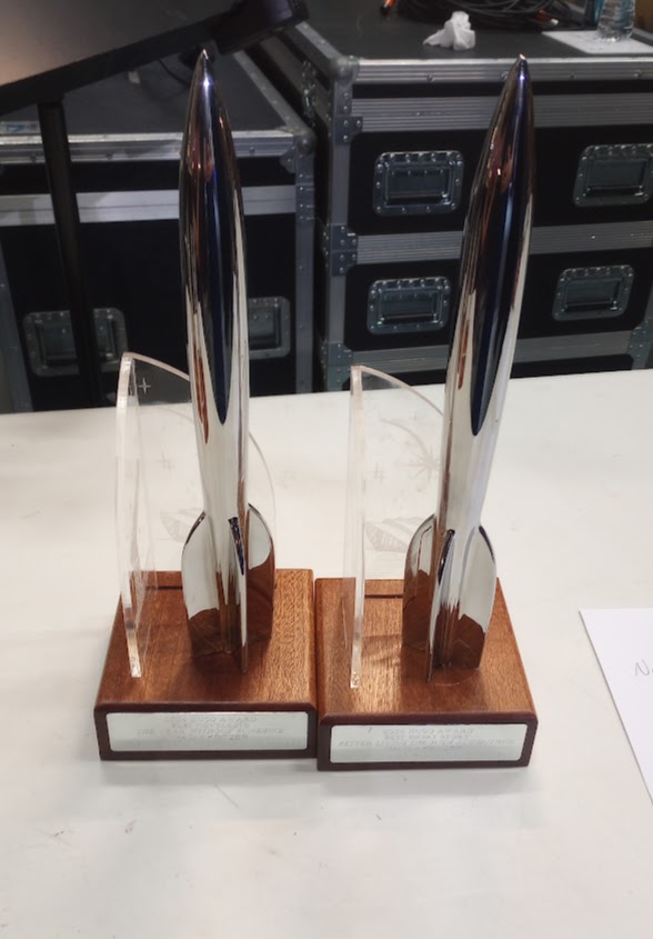 Two Hugo Award trophies (they are shaped like art deco style rocket ships on a wood base). 